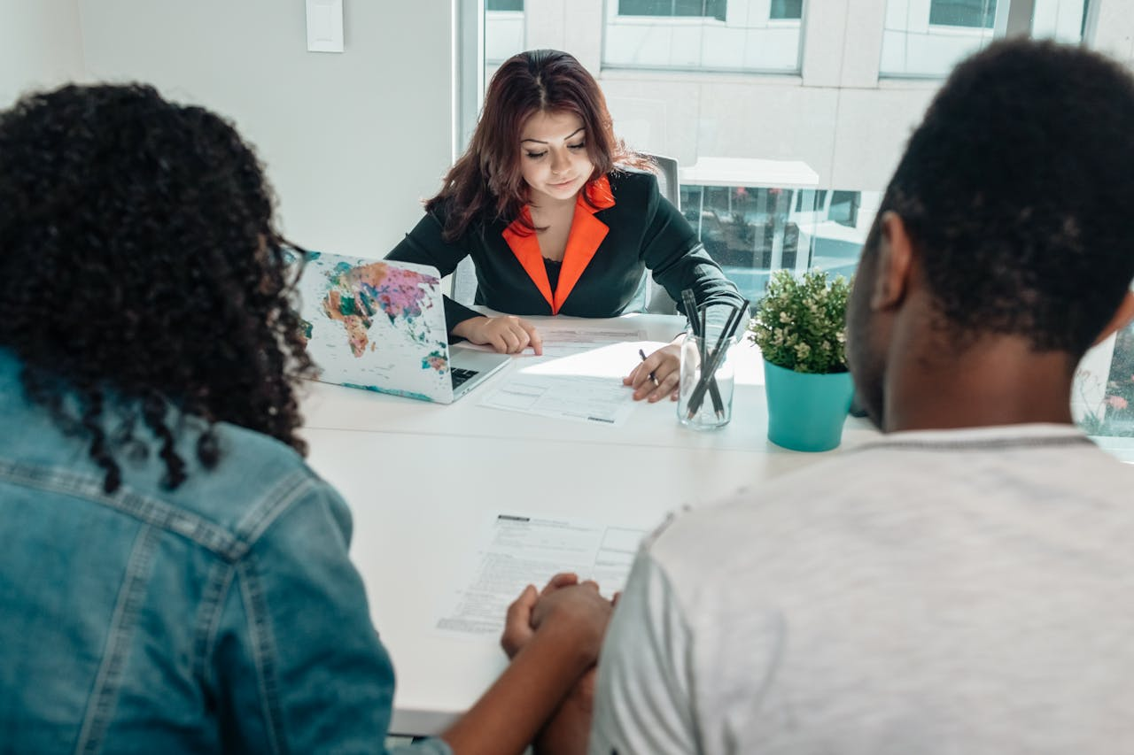 A couple discussing legal documents with a lawyer in a modern office environment.